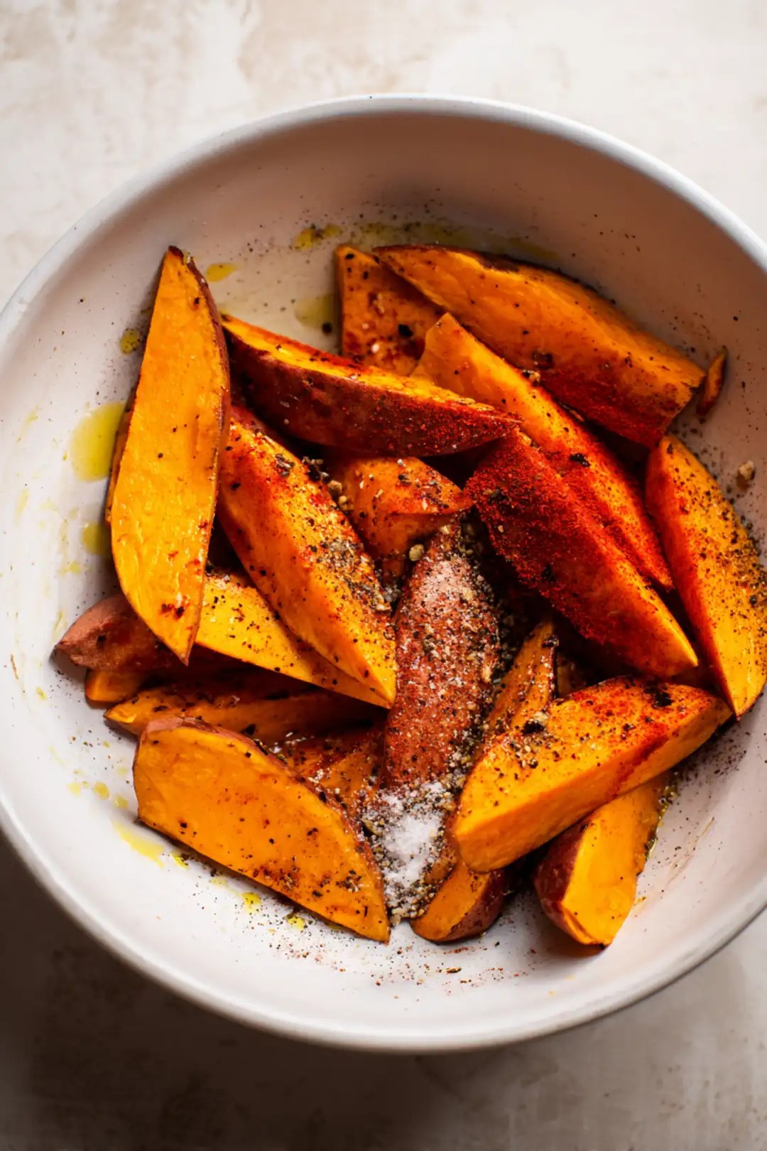 Combine sweet potato wedges with olive oil, salt, black pepper, and paprika