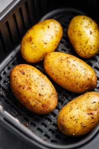 Rub the potatoes with olive oil and season with salt black pepper and garlic powder and place the prepared potatoes in the air fryer basket ensuring they are not overcrowded