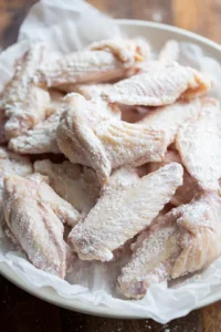 Coat chicken wings in cornstarch mixture and arrange on baking sheet