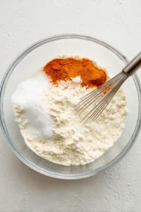 Combine flour, cornstarch, garlic powder, paprika, and salt in a large bowl