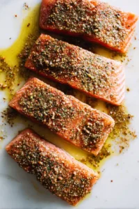 Rub the mixture evenly over the salmon fillets, coating them well.