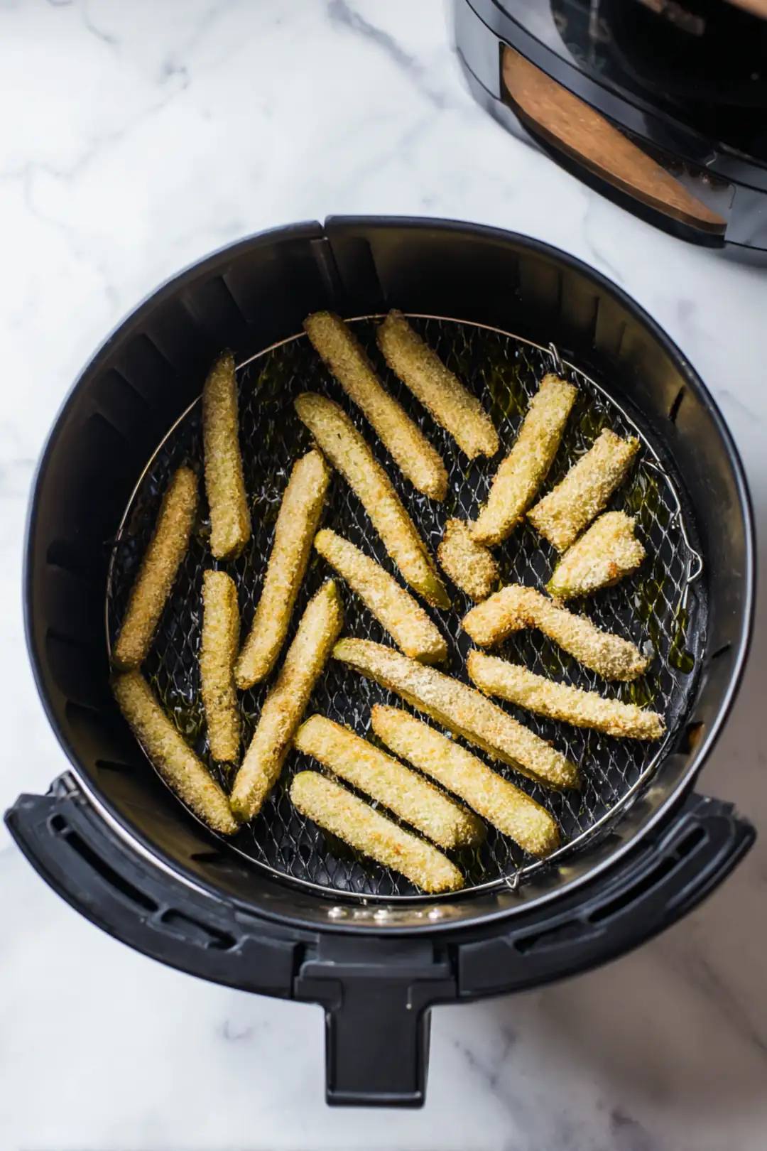 Arrange eggplant fries in air fryer and lightly spray with olive oil