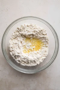 Combine whole wheat flour, salt, and oil in a large bowl to make a crumbly mixture and add water to form a smooth dough