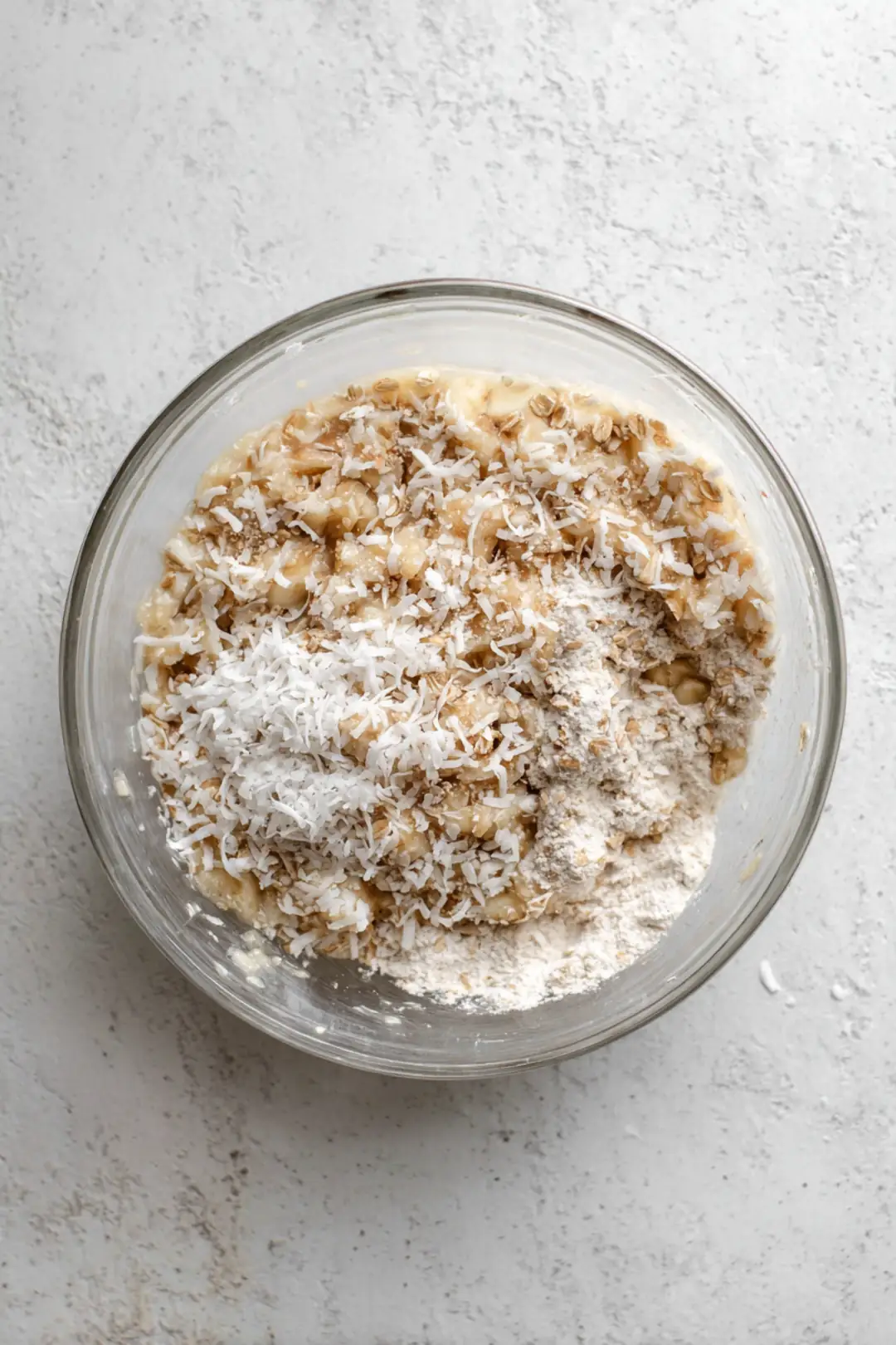 Mash the bananas until smooth and mix in the coconut, oats, vanilla, baking powder, and salt