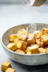 Sprinkle cornstarch over the marinated tofu and toss until evenly coated
