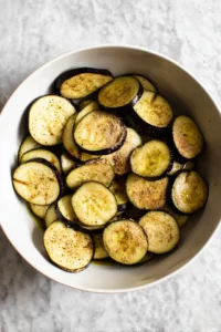 Toss sliced eggplant with olive oil and seasonings