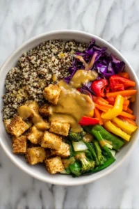 Assemble your quinoa bowl with crispy tofu and vegetables