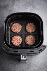 Preheat the air fryer and cook the patties