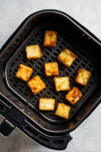 Preheat the air fryer and cook the tofu cubes
