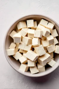 Press the tofu to remove excess moisture and cut it into cubes