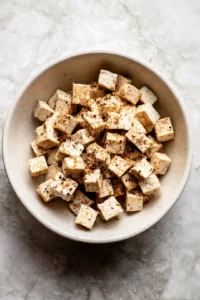 Toss tofu with soy sauce and spices