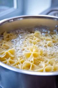 Add bowtie pasta to boiling water
