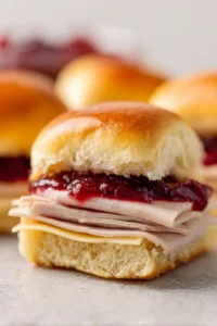 Arrange turkey breast and cranberry sauce on Hawaiian rolls