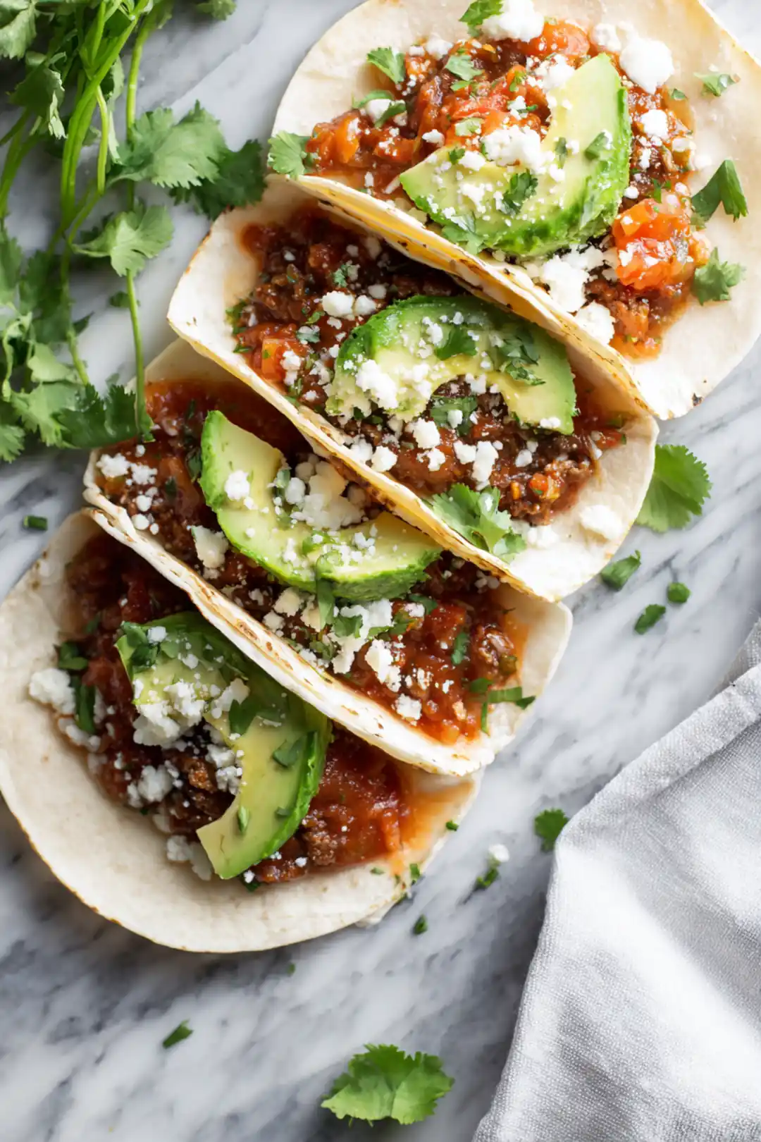 Assemble tacos with filling, cheese, salsa, and avocado