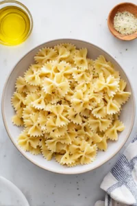Combine cooked bowtie pasta with olive oil and seasonings