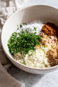 Combine ground chicken, breadcrumbs, egg, garlic powder, onion powder, salt, black pepper, and parsley in a mixing bowl