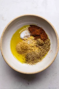 Combine protein options with olive oil, garlic powder, paprika, and salt