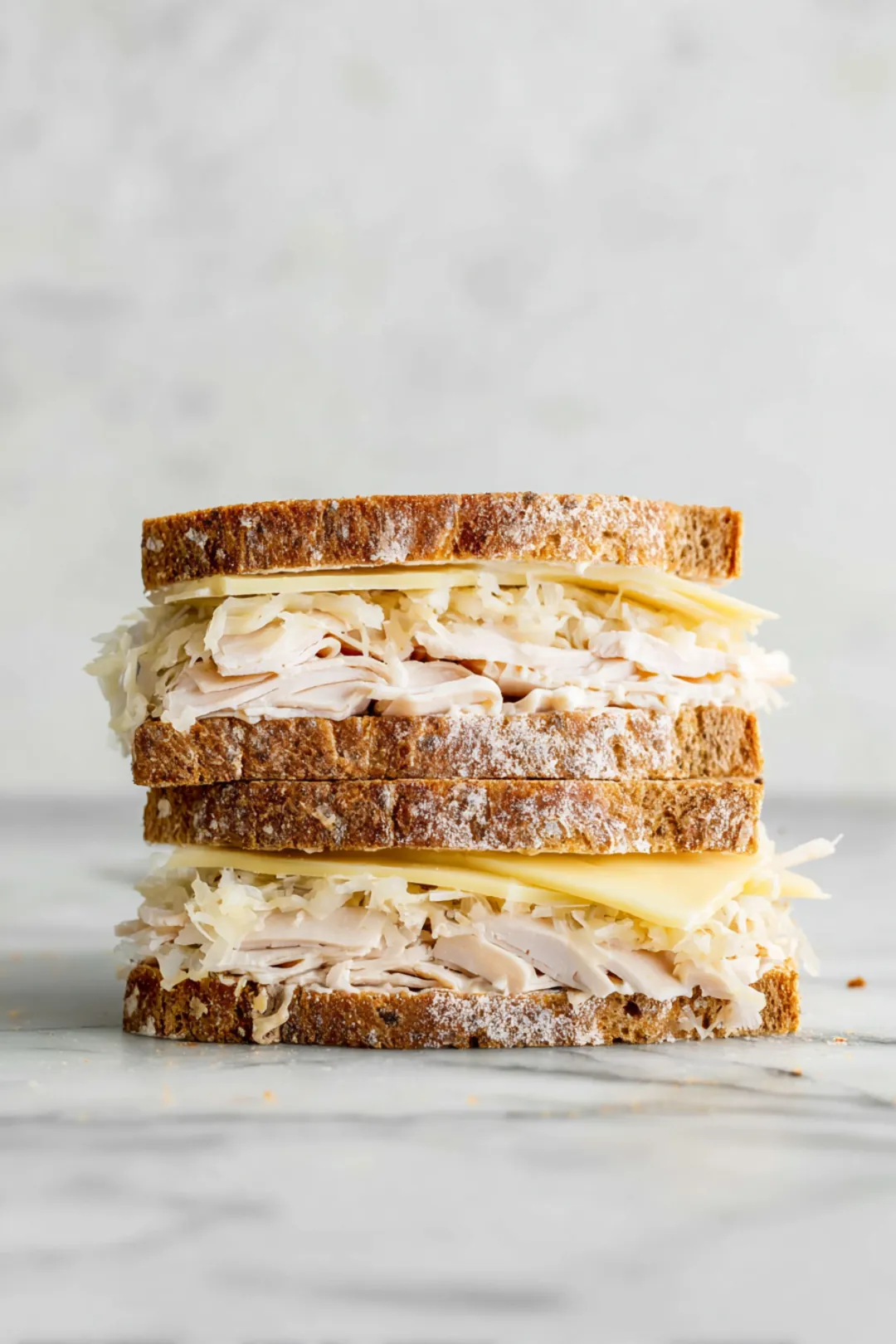 Layer two slices of whole grain bread with shredded turkey, drained sauerkraut, Swiss cheese, and a drizzle of Russian dressing. Top with the remaining bread slices.