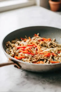 Preheat skillet and heat shredded protein with vegetables