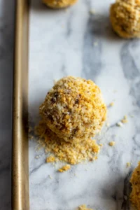 Roll each mixture ball in breadcrumbs and arrange on baking sheet