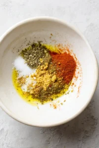 Rub the chicken leg quarters with a mix of olive oil, salt, black pepper, garlic powder, and paprika