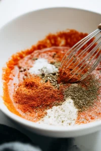 Add garlic powder, onion powder, smoked paprika, and black pepper to the sauce mixture then whisk until blended