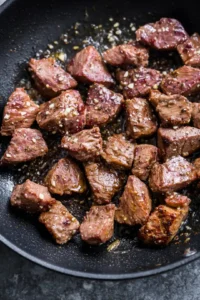 Add steak bites to the skillet and season with salt and black pepper