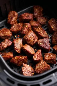 Arrange steak bites in air fryer and cook