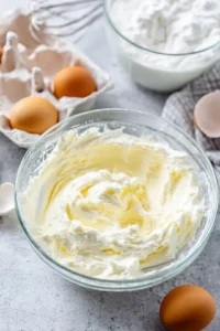 Beat cream cheese and sugar together until smooth, then add eggs one at a time, mixing well after each addition, followed by heavy cream and vanilla extract. Mix until fully combined and smooth.