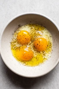 Beat eggs with olive oil, salt, and pepper