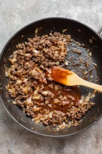 Brown ground beef with onion in skillet and add Big Mac sauce