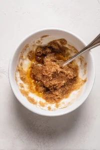 Coat peach halves in melted butter, brown sugar and cinnamon mixture