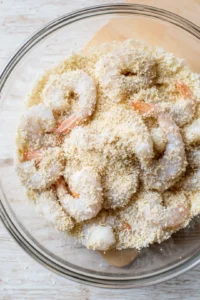Coat the shrimp in a mixture of panko breadcrumbs and coconut flakes