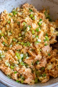 Combine canned salmon, bread crumbs, egg, green onions, garlic powder, onion powder, salt, and pepper in a bowl