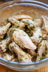 Combine chicken wings and dill pickle juice in a mixing bowl and refrigerate to brine for extra flavor