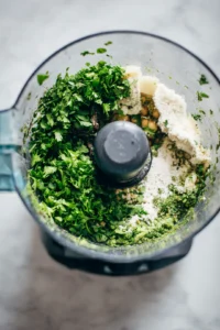Combine chickpeas, parsley, onion, garlic, cumin, coriander, salt, black pepper, and flour in a food processor, then pulse until coarsely blended