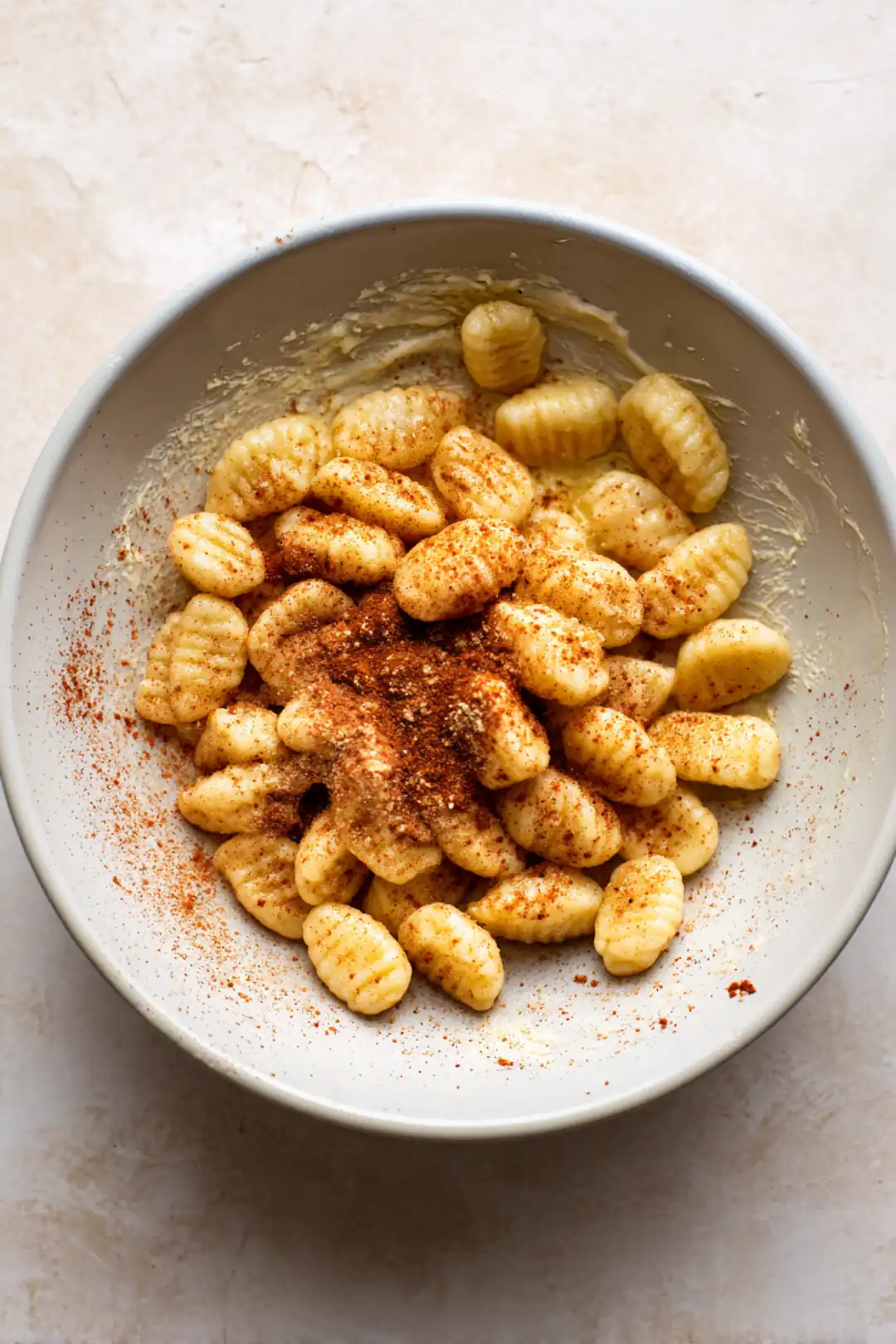 Combine gnocchi with olive oil, garlic powder, and paprika