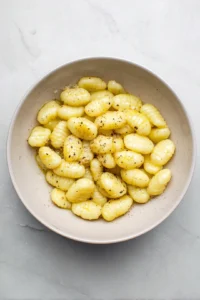 Combine gnocchi with olive oil, salt, and pepper