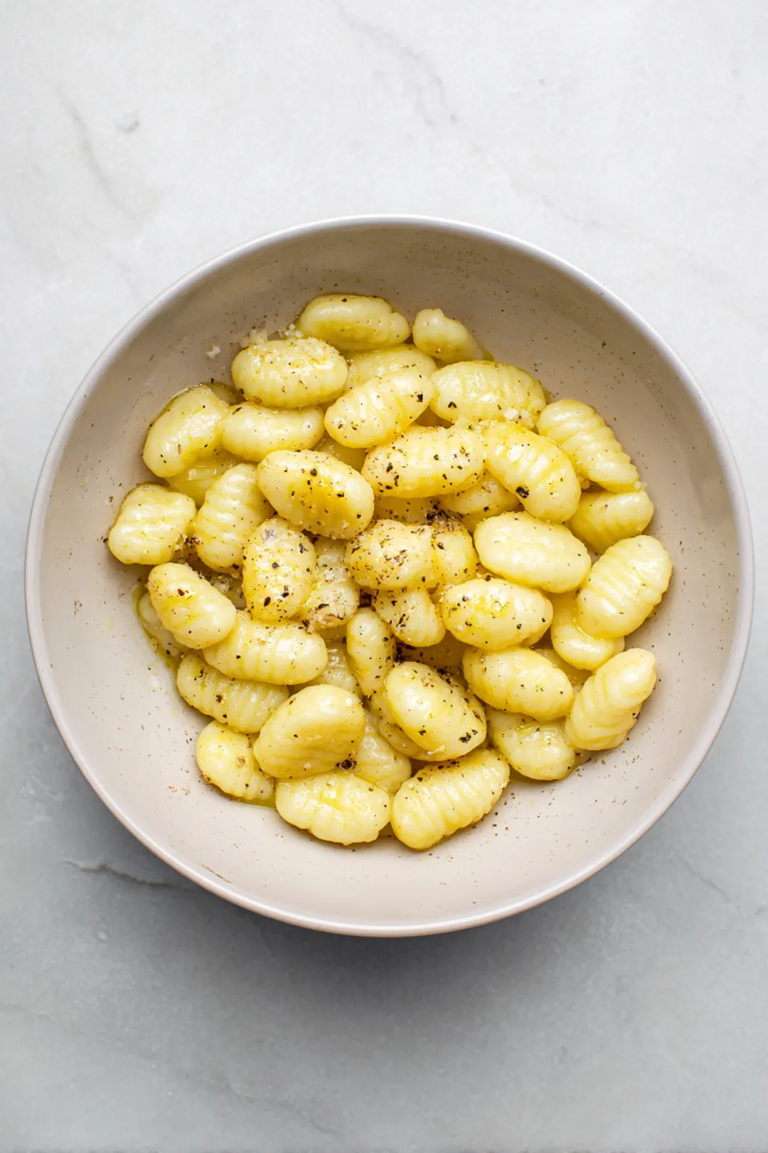 Combine gnocchi with olive oil, salt, and pepper