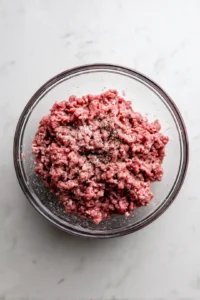 Combine ground beef with salt and pepper in a mixing bowl