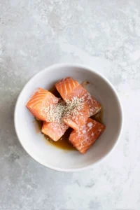Combine Kewpie mayo, soy sauce, and sesame oil, then marinate salmon fillets