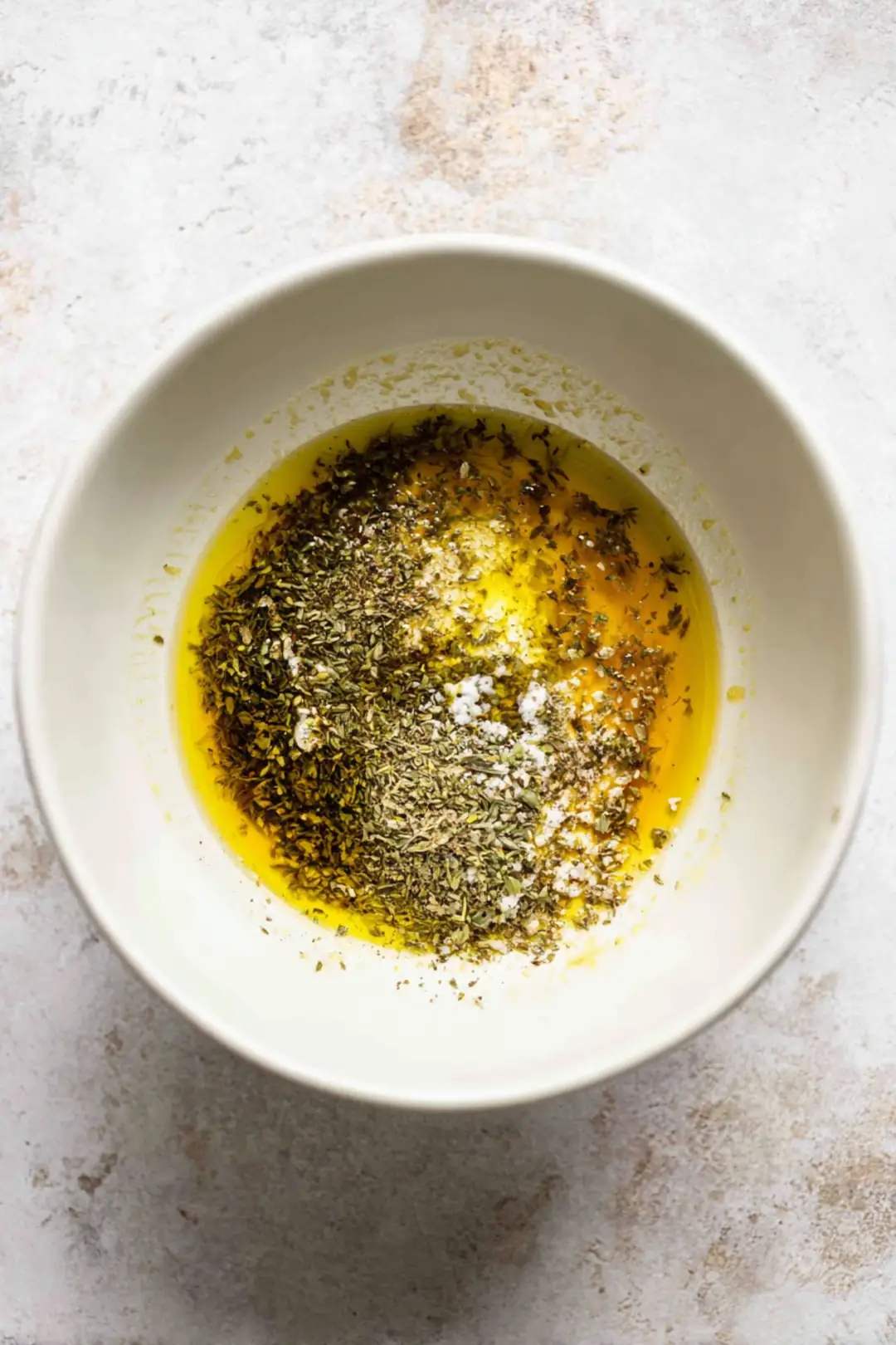 Combine lukewarm water, olive oil, lemon juice, and dried oregano to create a marinade