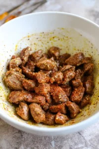 Combine melted butter, minced garlic, salt, pepper, and paprika with steak bites