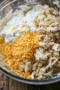 Combine shredded chicken, cream cheese, and shredded cheese in a large mixing bowl