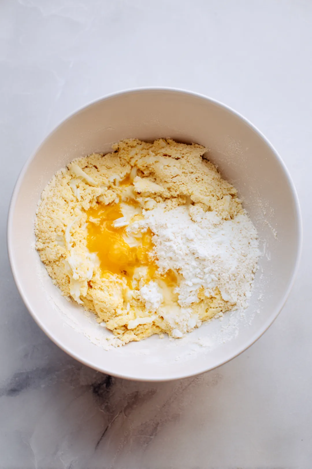 Combine shredded chicken, egg, mozzarella cheese, and almond flour to form a dough for the crust