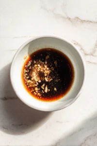Combine soy sauce, brown sugar, minced garlic, and black pepper in a bowl to create the marinade