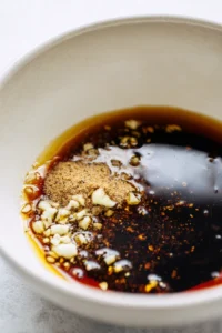 Combine soy sauce, minced garlic, and black pepper for marinade