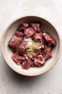 Combine steak pieces with olive oil and seasonings