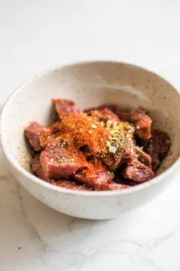 Combine the steak bites with olive oil, garlic powder, paprika, salt, and black pepper