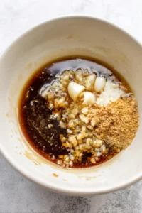 Combine water, soy sauce, vinegar, brown sugar, minced garlic, and chopped onion to create the marinade